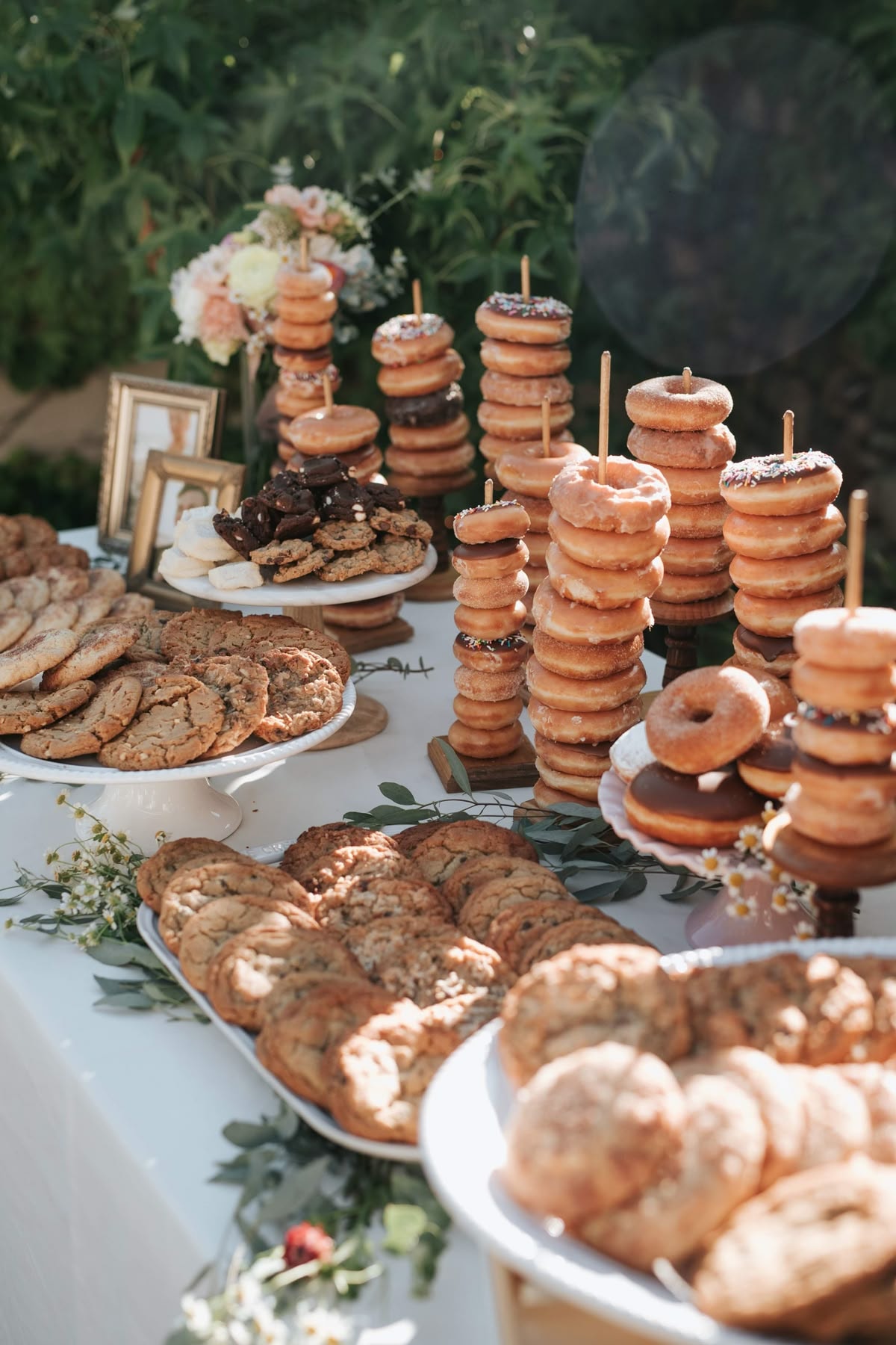 Outdoor dessert table with stacked donuts and cookies